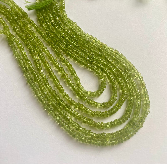 Strands of smooth green peridot beads, ranging from 3.5mm to 4mm in size, showcasing their vibrant colour and shine.  