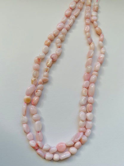 Elegant strands adorned with 4-5.5mm opal smooth tumble beads, showcasing a sleek design.