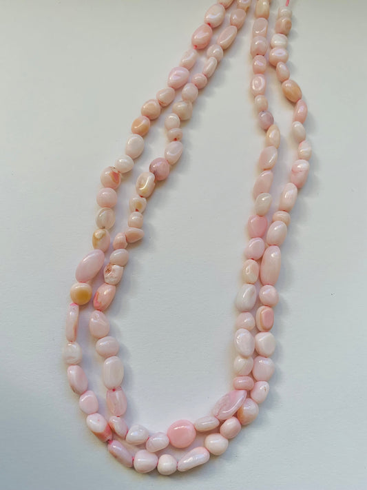 Elegant strands adorned with 4-5.5mm opal smooth tumble beads, showcasing a sleek design.