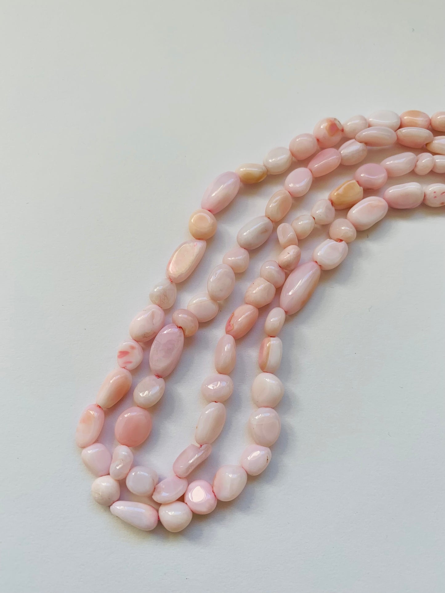 Elegant gemstone strand adorned with 4-5.5mm smooth pink opal beads, highlighting the beauty of opals.