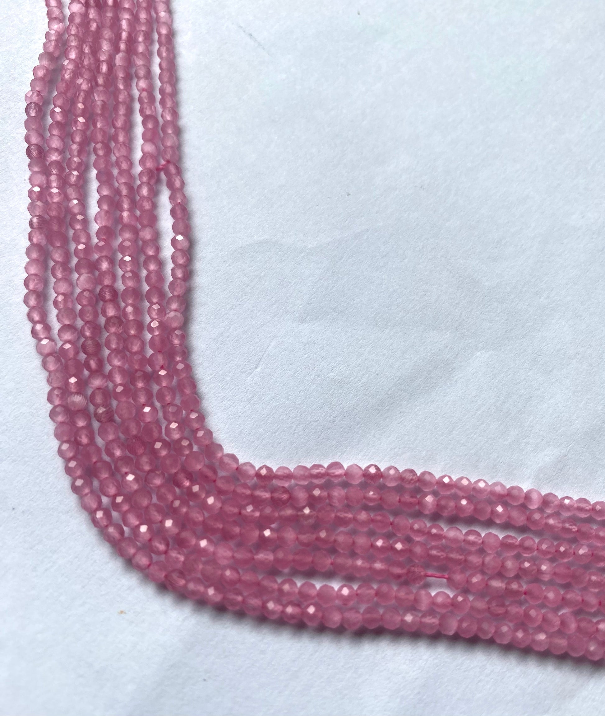 A close-up of a strands of faceted quartz beads, measuring 2.5mm, highlighting their rich, vibrant hue.  