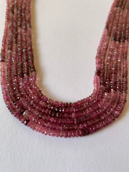 Strands of Faceted Rondelle Pink Tourmaline beads, ranging 3.5mm or 4mm in size, showcasing their vibrant colour and shine.