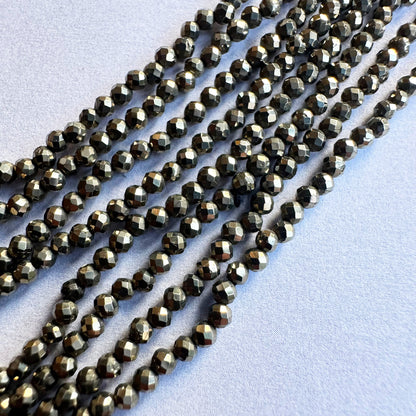 Strands of 2.1mm Pyrite faceted rondelle beads display exceptional clarity and uniform cutting.
