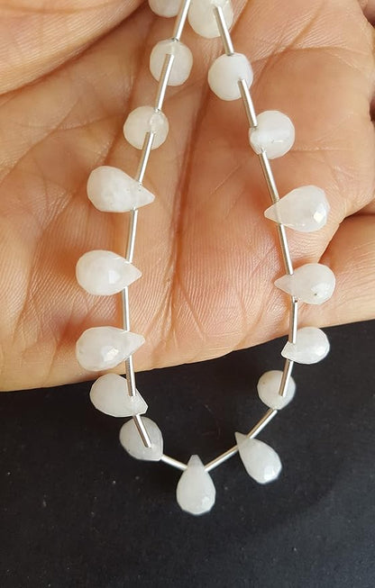 A person holds a strand made of rainbow moonstone faceted teardrop beads featuring vibrant gemstones. 