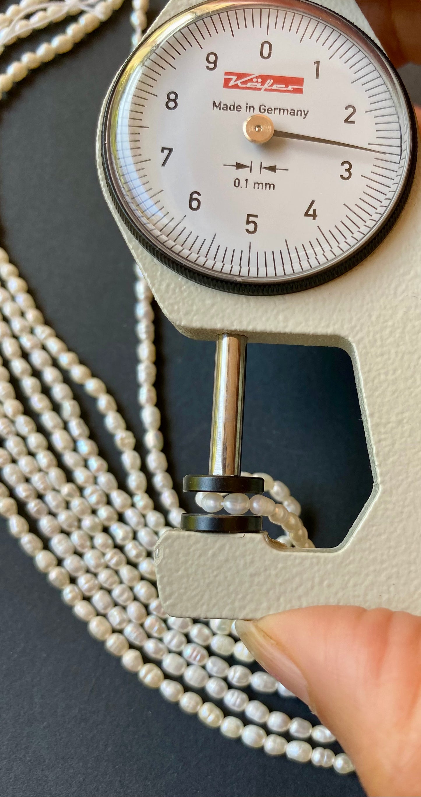 A dial gauge measures the  Rice Pearls Oval 2.5-2.75mm gemstone.