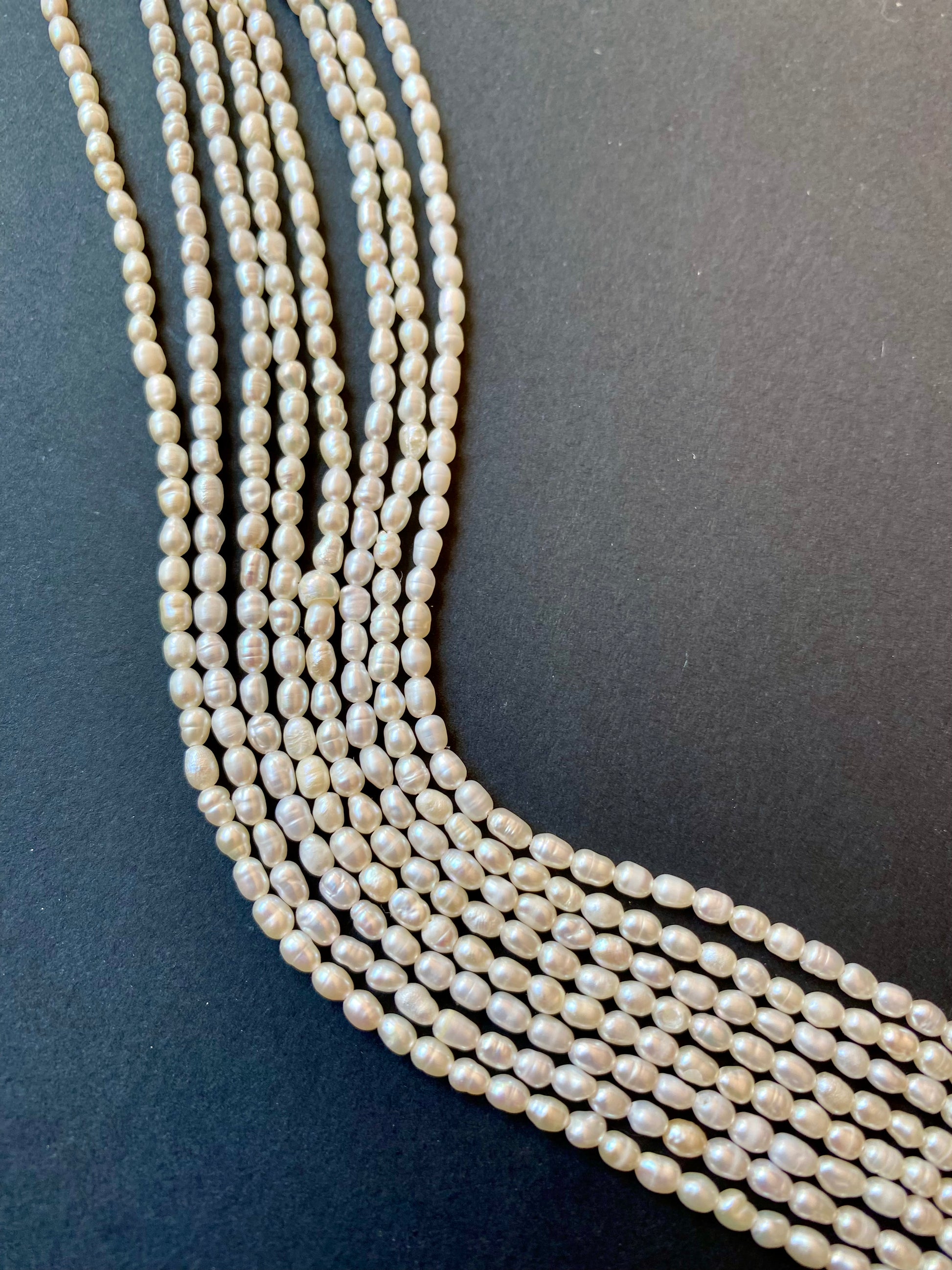 A cluster of Oval  Rice Pearls natural beads,sized 2.5-2.75mm showcasing their rich colour and rough texture.