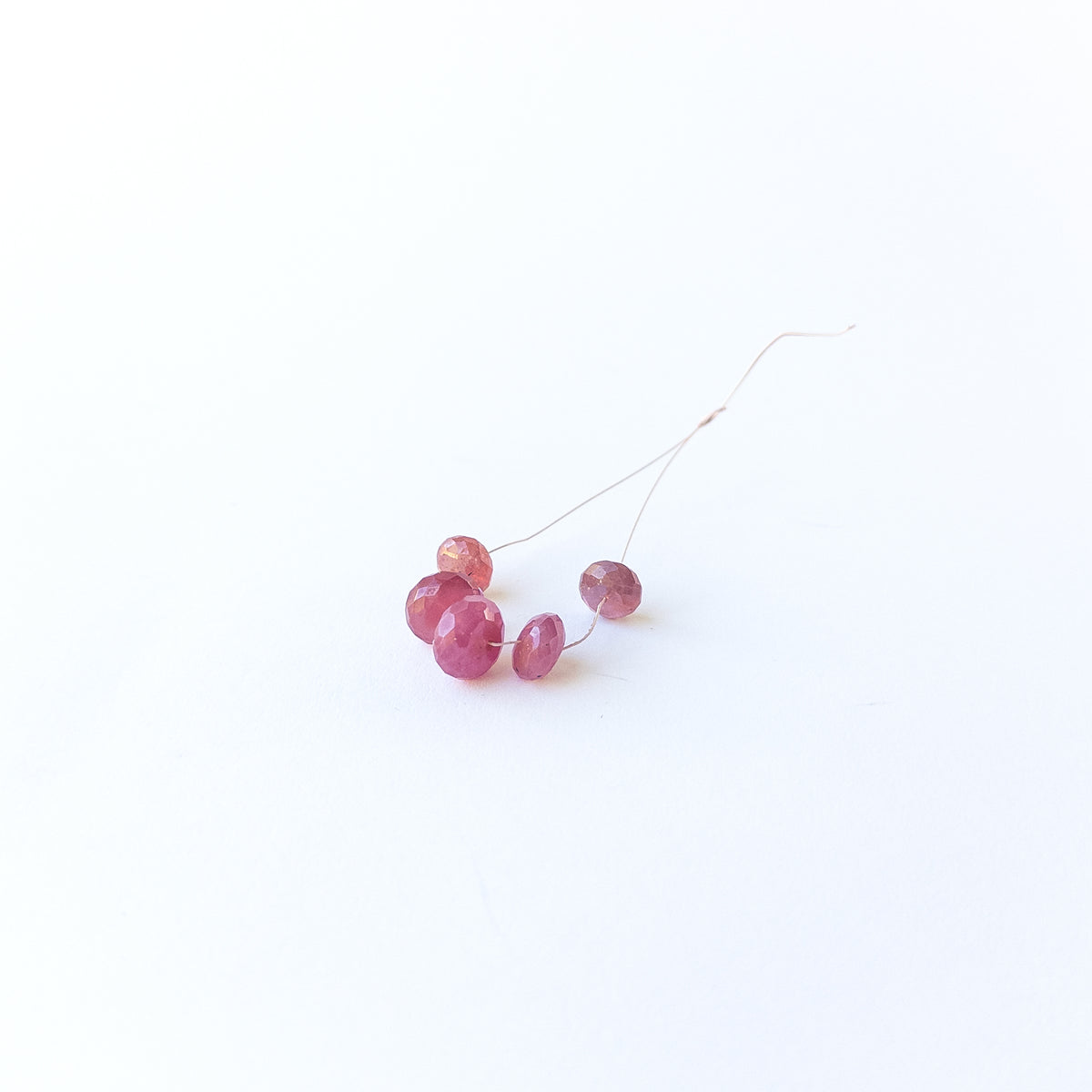 Close‑up of Ruby faceted rondelle beads showing their lustrous surface and brilliant light play.