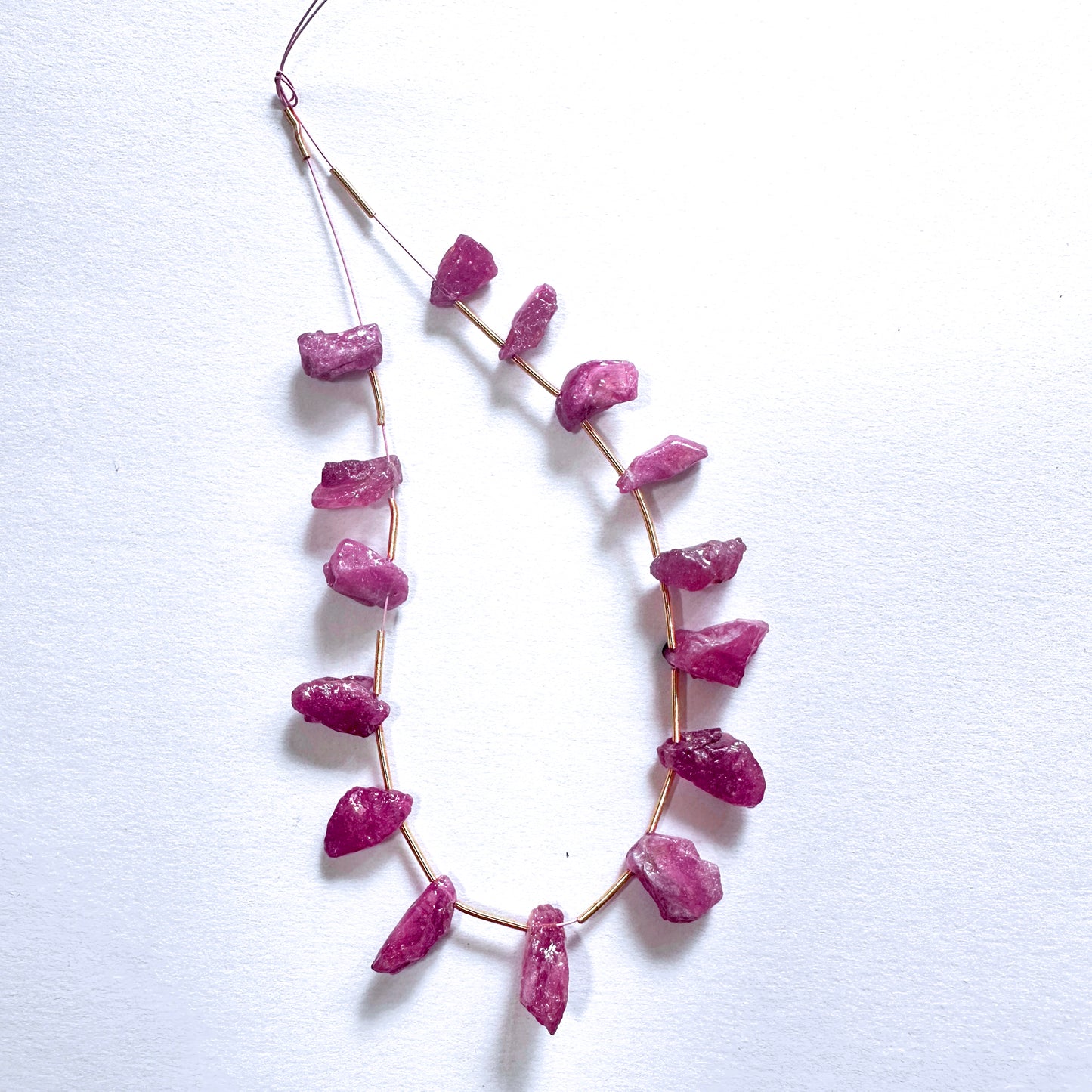 Faceted ruby gemstones in rough cut show deep crimson hues and organic surface shine.