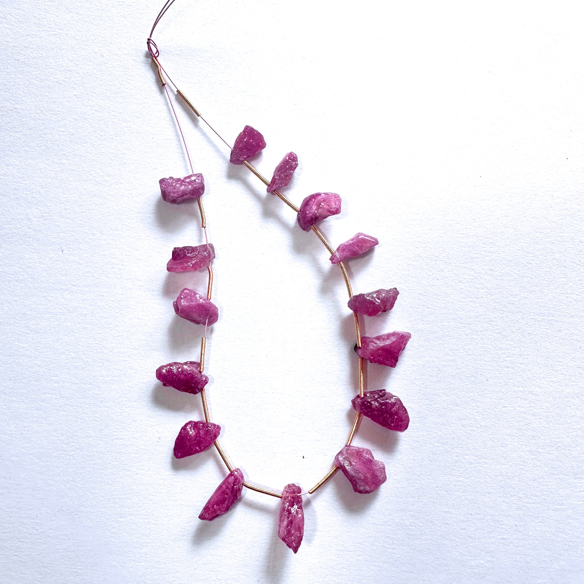 Faceted ruby gemstones in rough cut show deep crimson hues and organic surface shine.
