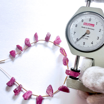 A dial gauge measures the ruby rough side drilled 6mm gemstone for accuracy and quality.