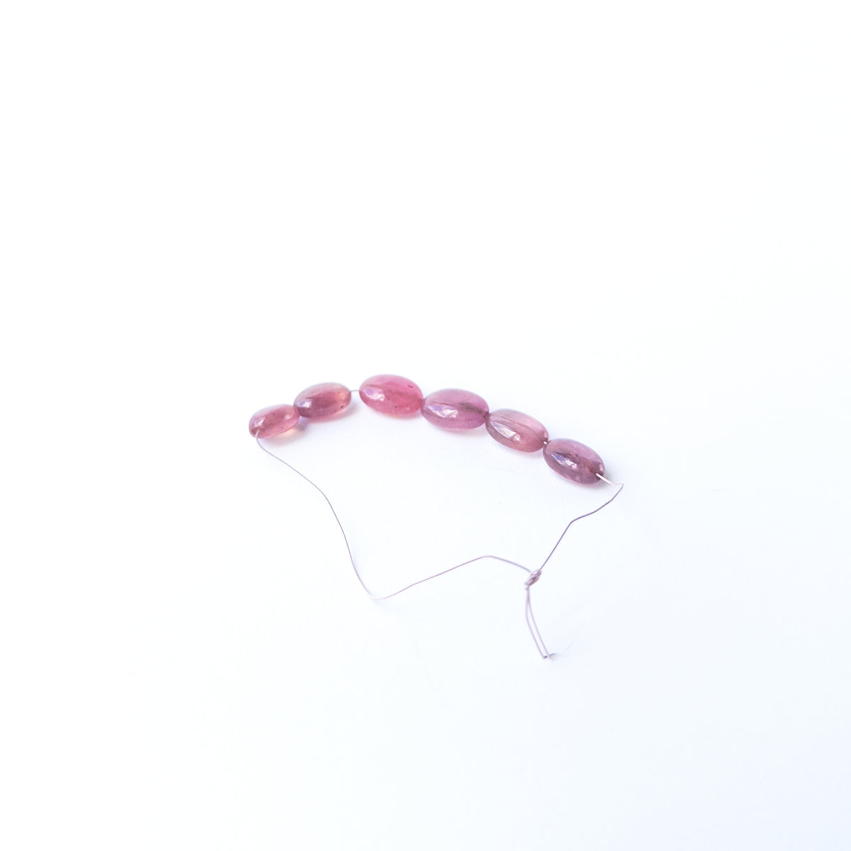 Authentic Ruby oval beads showcasing polished shine and vibrant crimson tones.