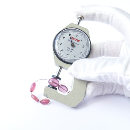 A dial gauge measures the Ruby smooth oval 7–8.9mm gemstone.
