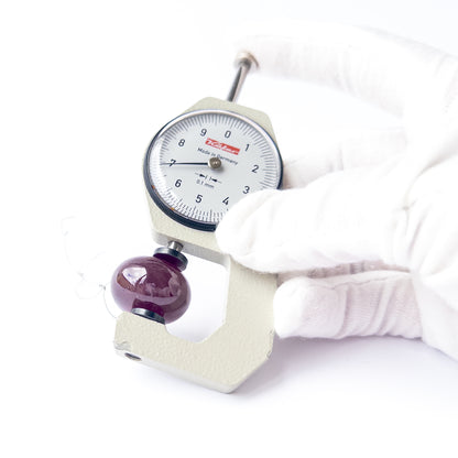 A dial gauge measures the Ruby smooth rondelle 23mm gemstone.