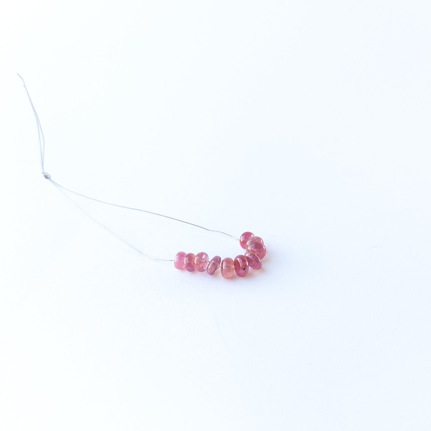 Ruby smooth rondelle gemstone beads with rich red colour arranged in a 5–6mm set for jewellery making.