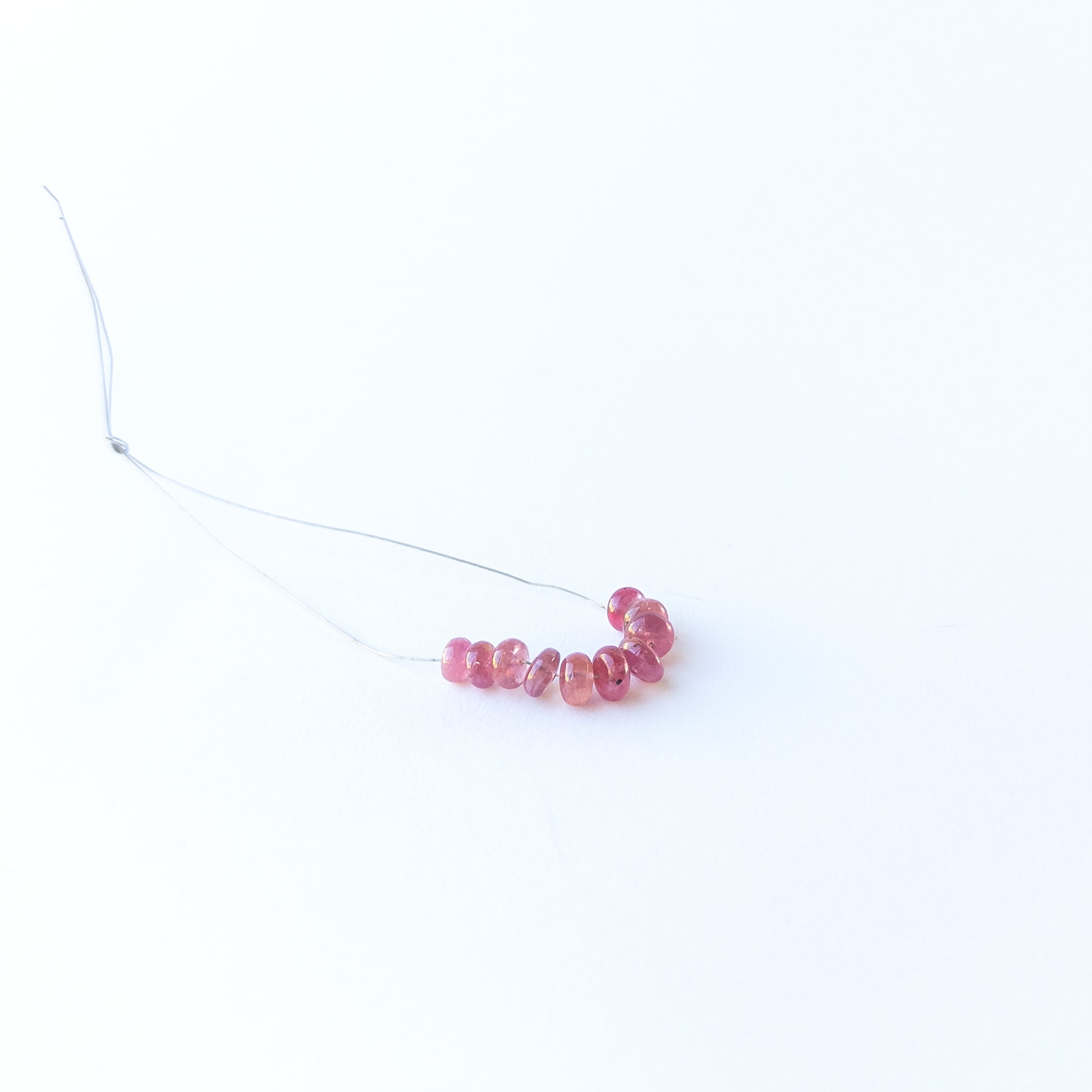 Ruby smooth rondelle gemstone beads with rich red colour arranged in a 5–6mm set for jewellery making.