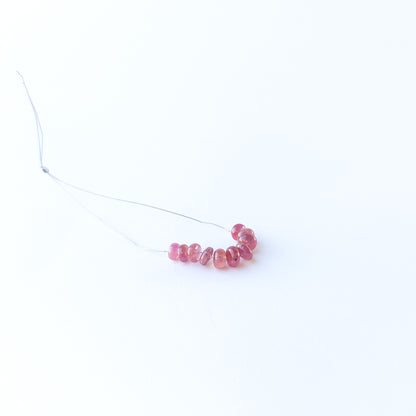 Ruby smooth rondelle gemstone beads with rich red colour arranged in a 5–6mm set for jewellery making.
