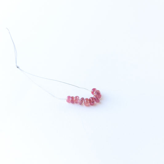 Ruby smooth rondelle gemstone beads with rich red colour arranged in a 5–6mm set for jewellery making.