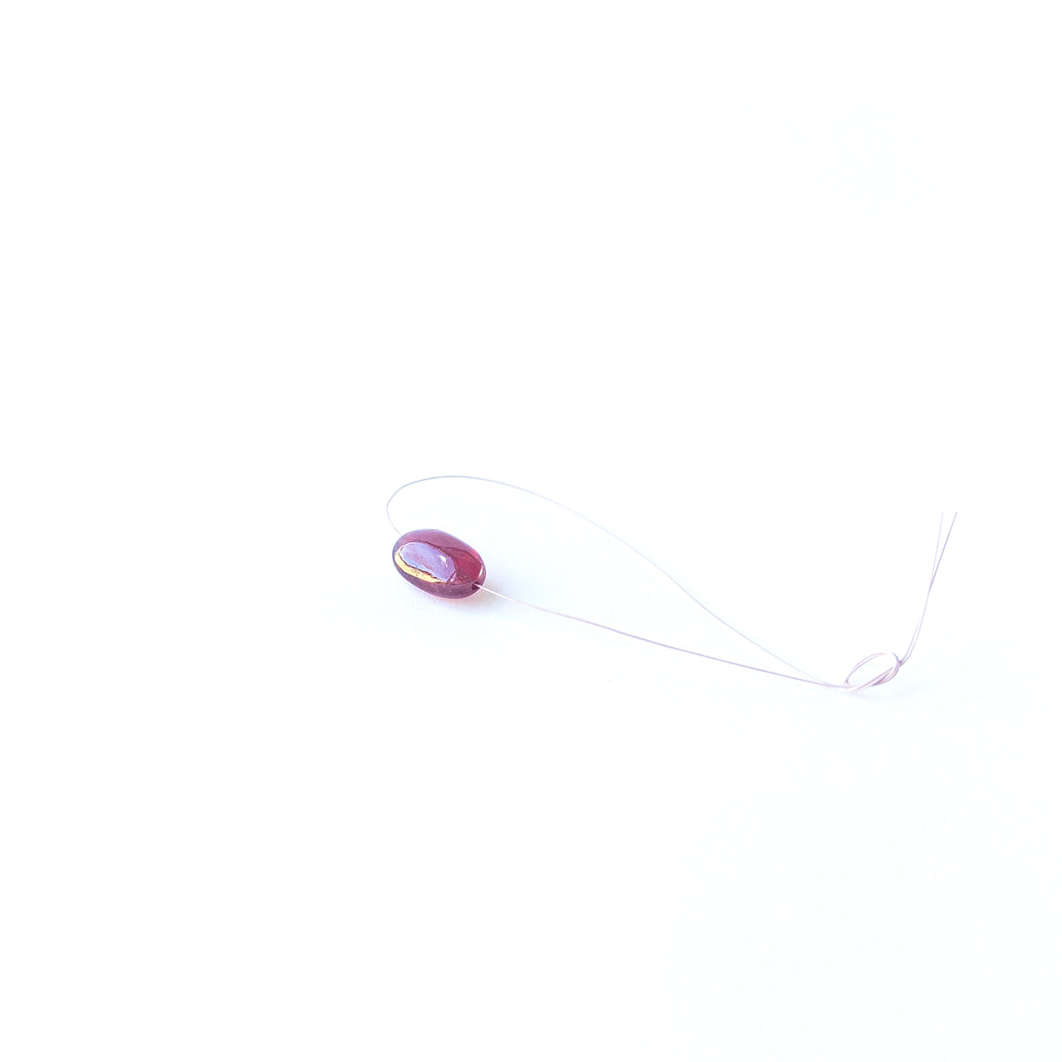 Genuine Ruby stone bead showcasing its smooth tumble shape and rich crimson tone.