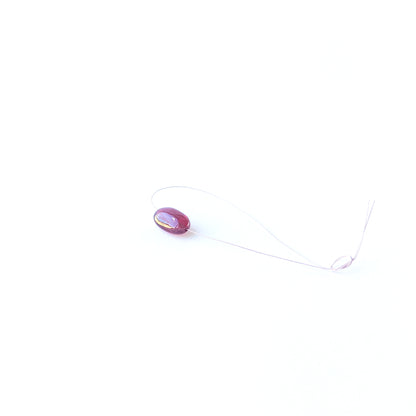 Genuine Ruby stone bead showcasing its smooth tumble shape and rich crimson tone.