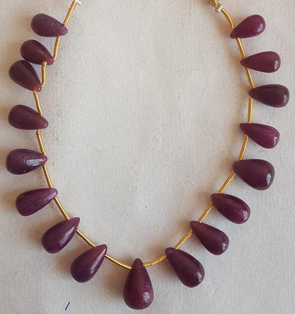 A stunning red ruby beads, elegantly hung from a delicate gold tassel.