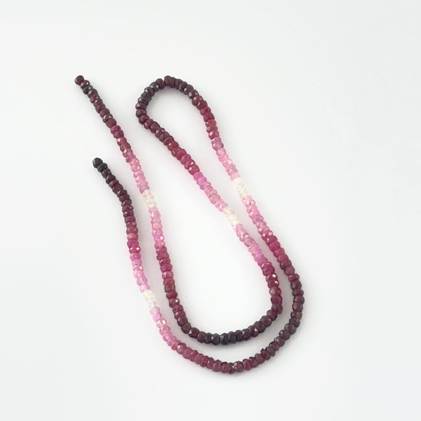 Macro view of 3.4mm Ruby beads showing shaded red to pink gradient