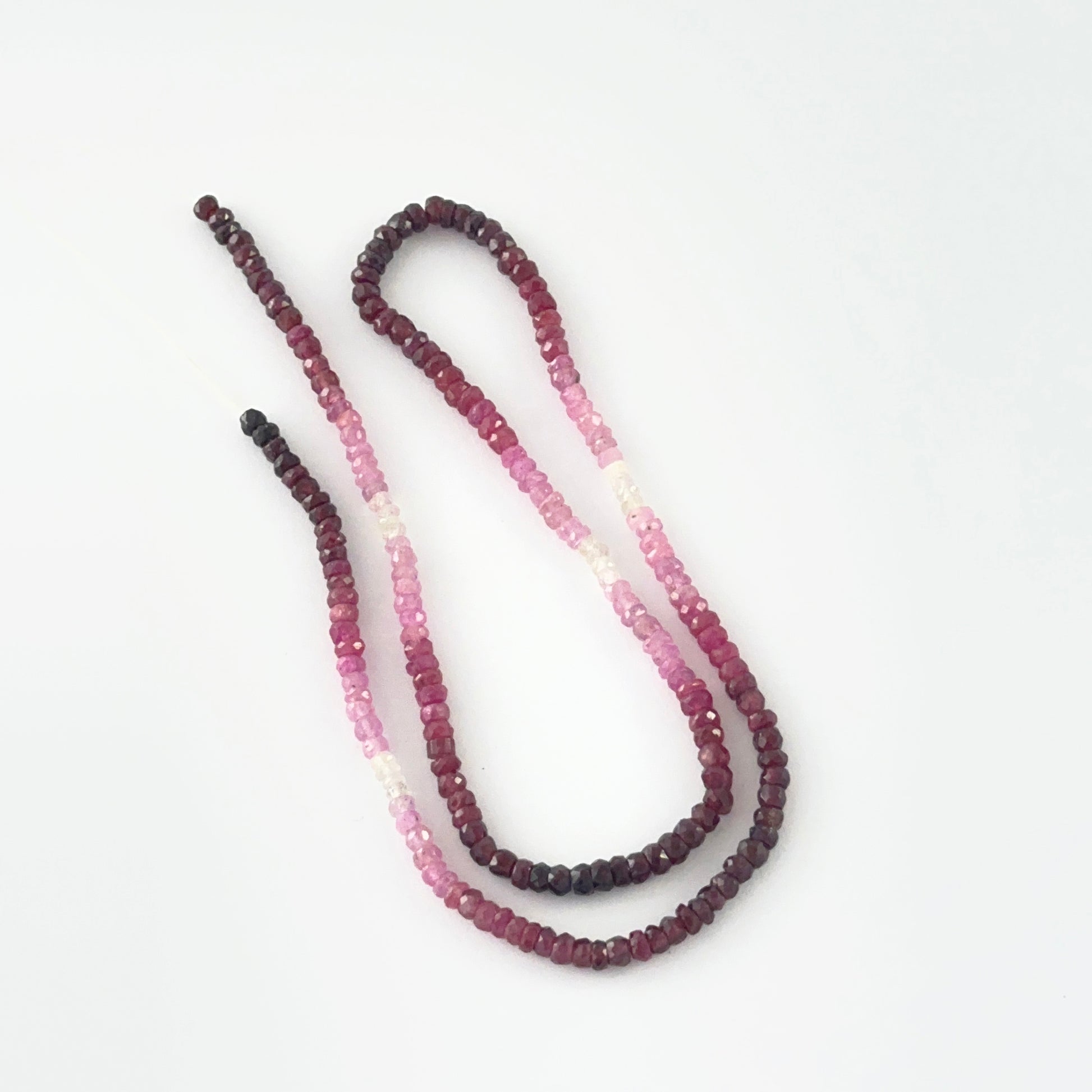 Macro view of 3.4mm Ruby beads showing shaded red to pink gradient