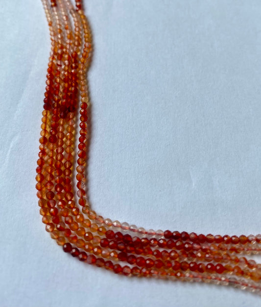 Carnelian micro faceted rondelle gemstone beads in rich orange-red tones on a 32cm strand.