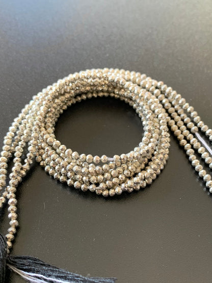 A long strand of 2.2mm sliver pyrite beads, showcasing faceted rondelles, ideal for crafting and design.