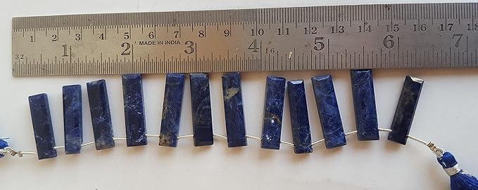 A ruler measures the Sodalite faceted rectangle briolette semi-precious gemstone.