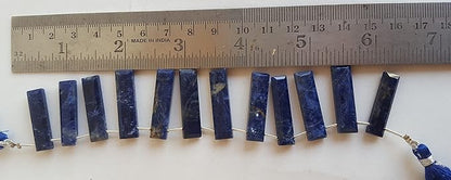 A ruler measures the Sodalite faceted rectangle briolette semi-precious gemstone.