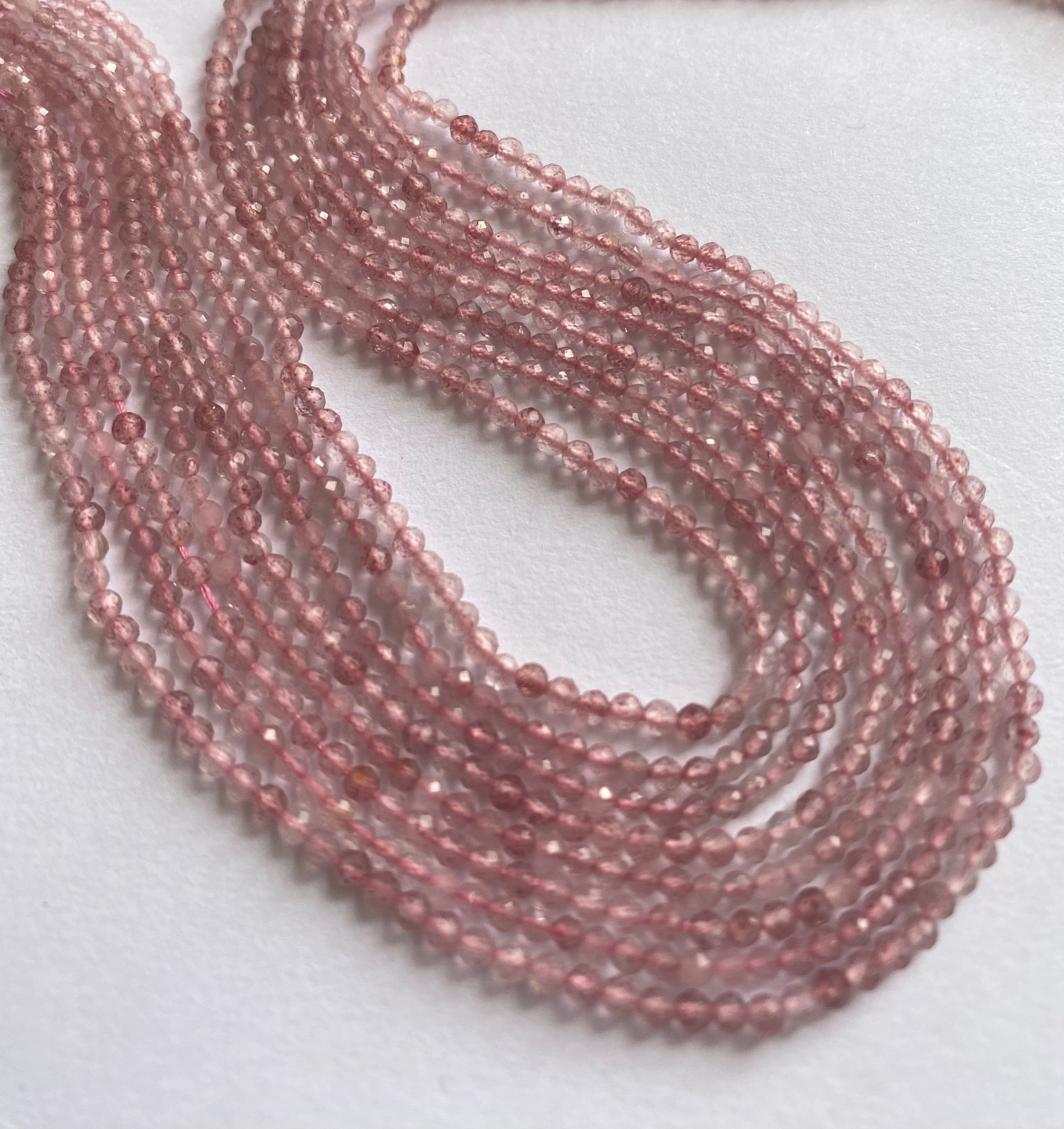 Close-up of Strawberry Quartz faceted rondelle beads, highlighting their refined cut and soft blush tones.