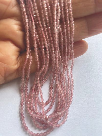 Strawberry Quartz faceted rondelles laid out in rows, revealing consistent bead quality and symmetry.