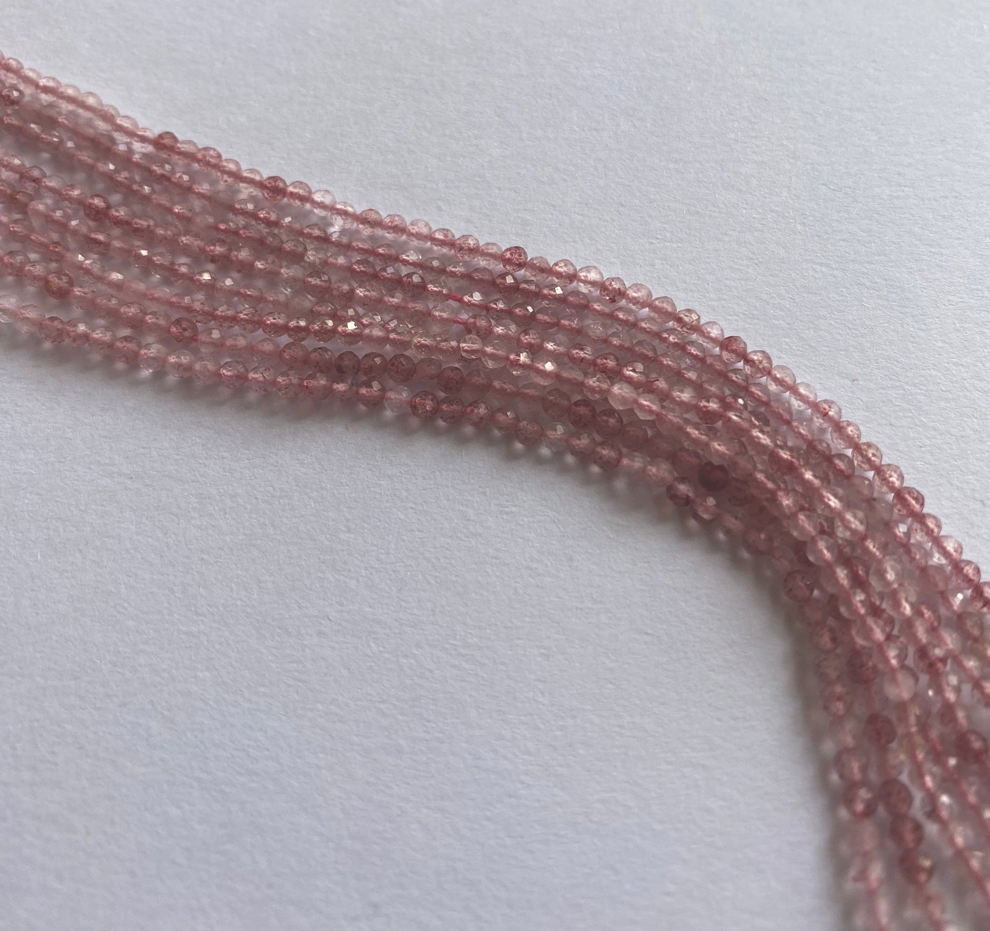Glowing Strawberry Quartz rondelle beads shimmer under light, enhancing their natural sparkle and translucency.