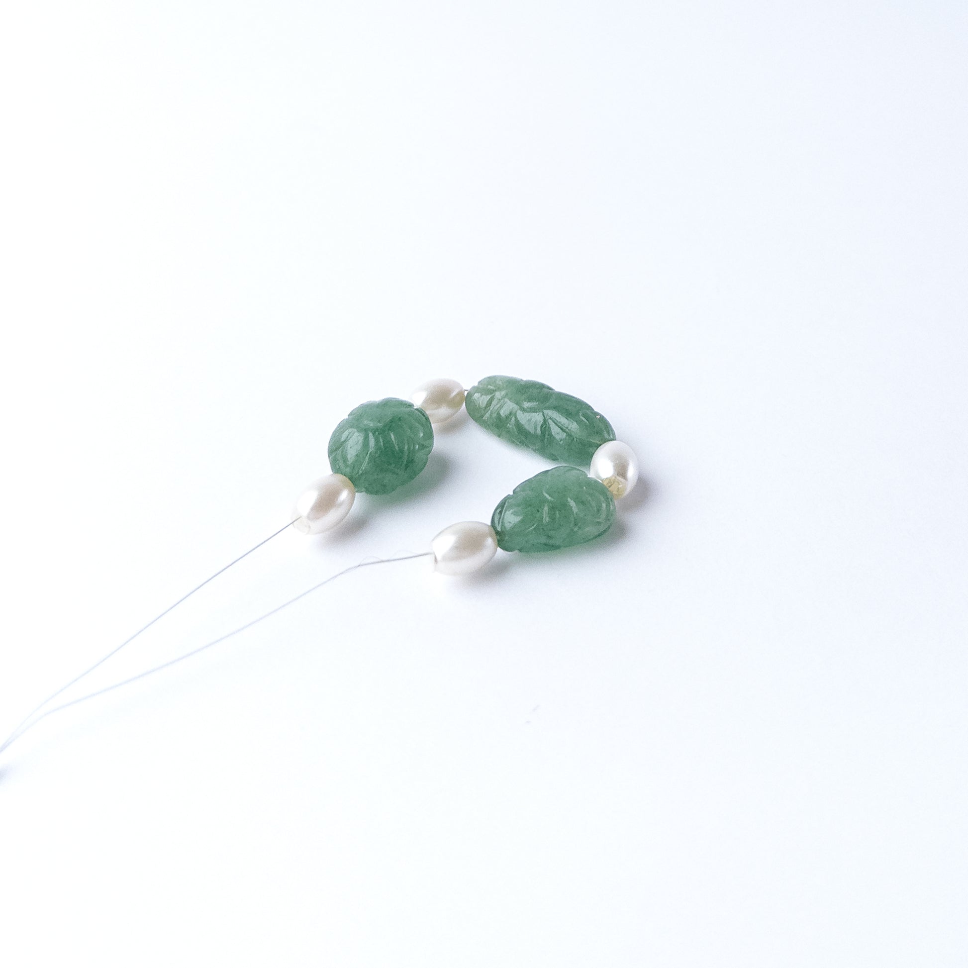Green Strawberry Quartz and Shell Pearl gemstone beads arranged in a mixed set for jewellery crafting.