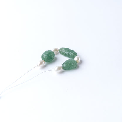 Green Strawberry Quartz and Shell Pearl gemstone beads arranged in a mixed set for jewellery crafting.