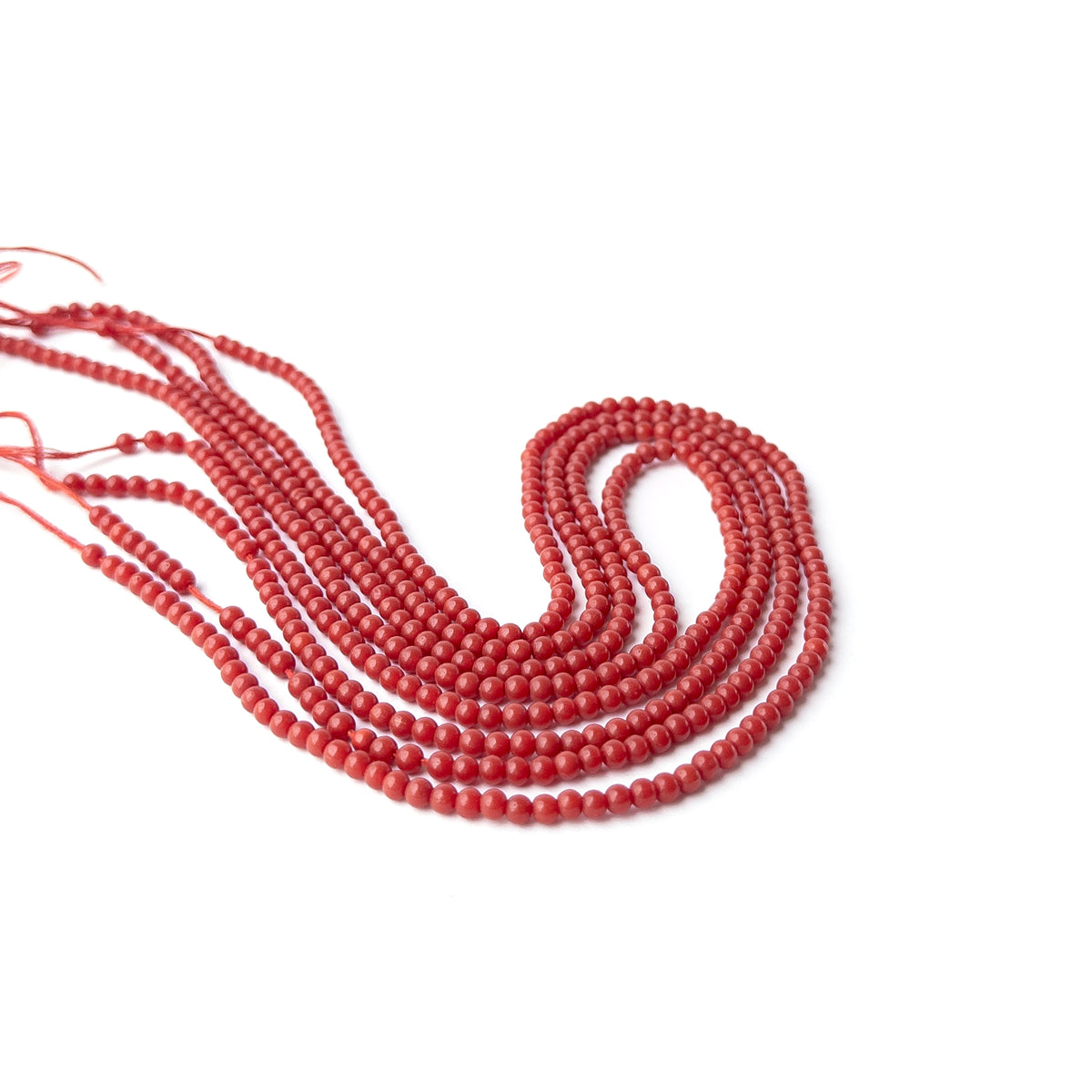 Genuine Taiwan Coral gemstone beads arranged on a 19cm strand with approximately 62 uniform round beads.