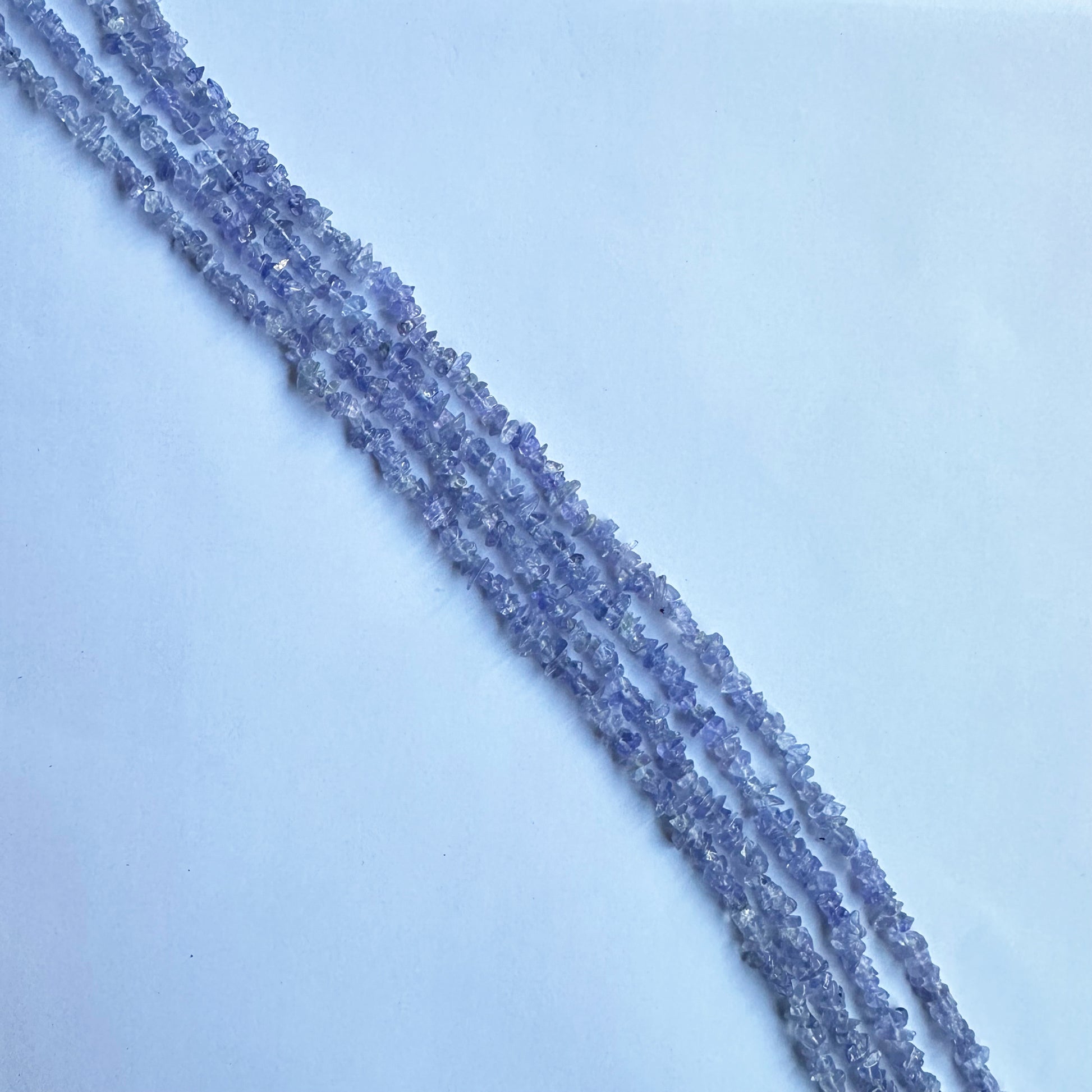 Uncut Tanzanite strands coiled together, emphasizing their deep hues and versatility in jewelry designs.