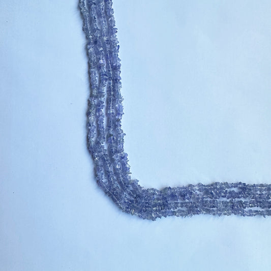 Close-up of Tanzanite uncut chips, highlighting their organic shape, faceted shimmer, and deep blue-purple tones.