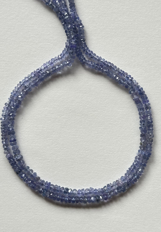 Strands of faceted blue Tanzanite rondelle gemstone beads, measuring 2.4mm to 3mm, showcasing their vibrant colour and shine.