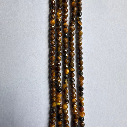 Jewellery artisan lines up Tiger Eye rondelles, highlighting the quality and colour variation.