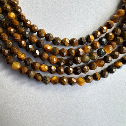 Close-up of Tiger Eye rondelle beads reveals expert faceting and vivid golden-brown colour.