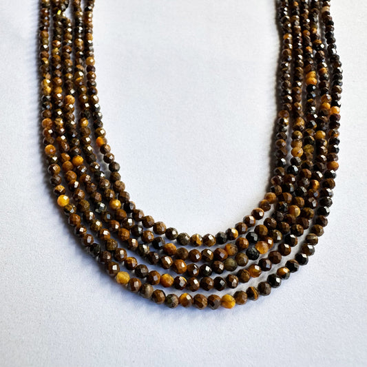 Tiger Eye gemstone beads sparkle under light, enhancing their detailed micro-faceted surface.