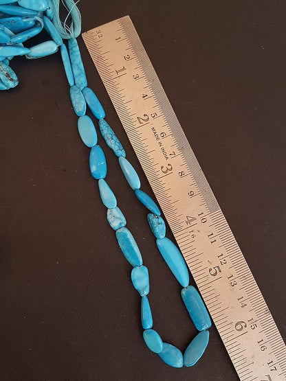  A blue turquoise stand made of smooth, tumble beads, with a ruler beside it for size reference. 
