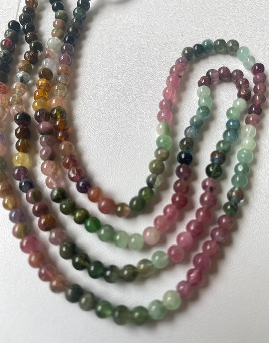 Multi-strands made of 4.1mm smooth round tourmaline beads, displaying a stunning array of colours and textures.