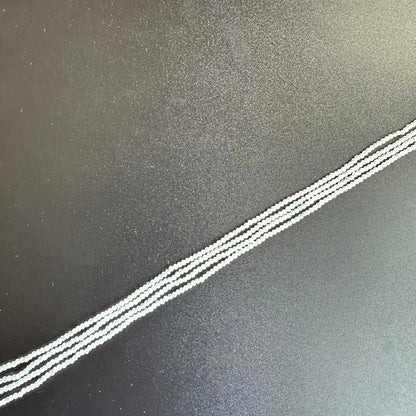 Close-up of White Rainbow Moonstone beads reveals their subtle iridescence and fine faceting.