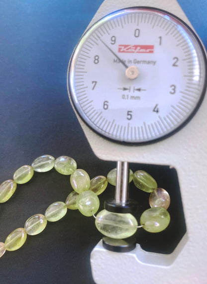 A dial gauge measures the Yellow Sapphire smooth oval gemstone.