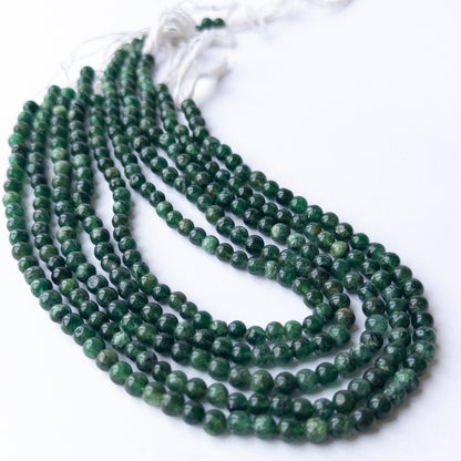 Aventurine smooth round beads displayed in multiple strands, showing consistent sizing and natural variation.