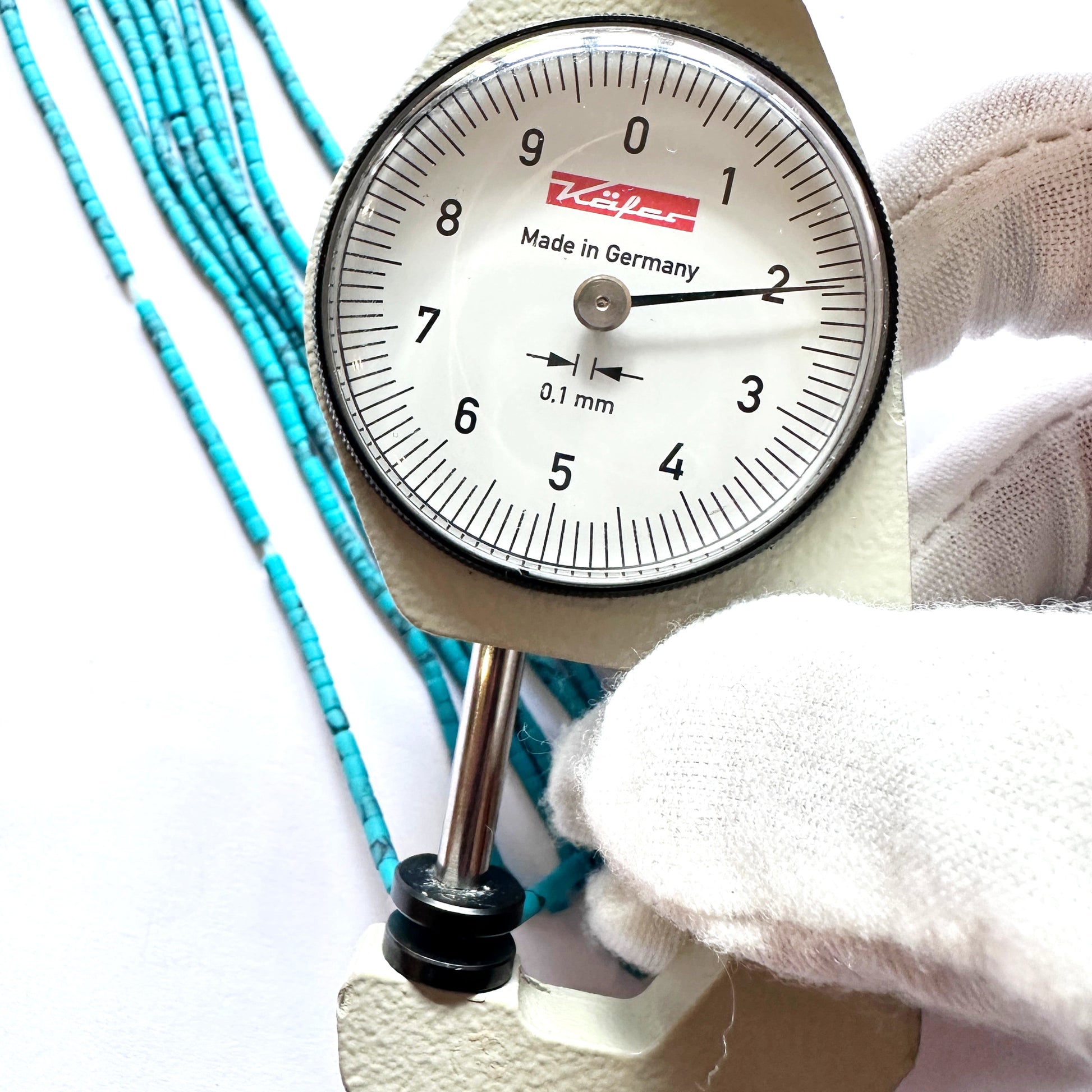 A dial gauge measures the Afghan tube-shaped Heishi 2.0mm gemstone.