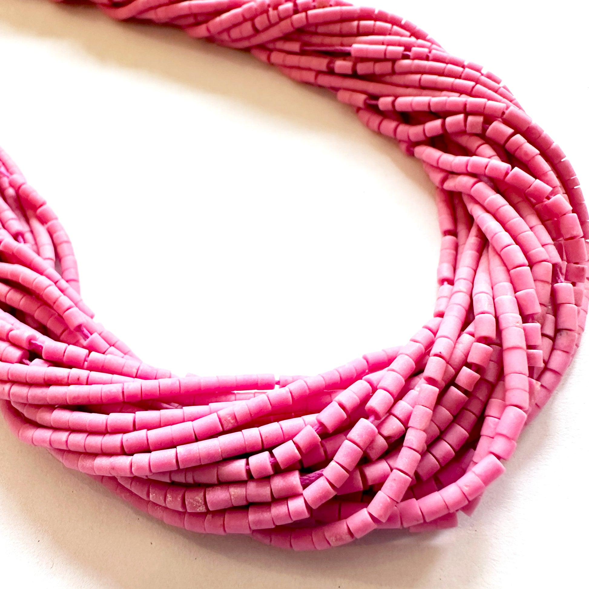 Finely shaped Afghan Pink Tube Heishi beads aligned to display cut precision and colour harmony.