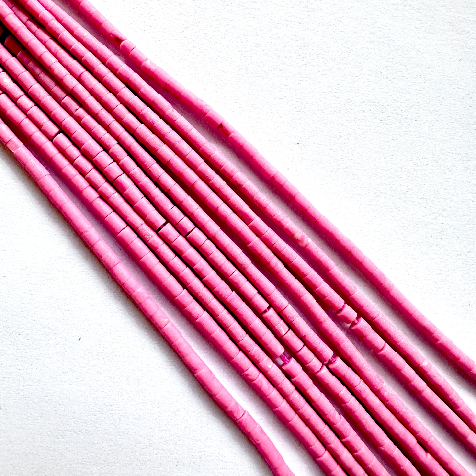 Close up of Pink afghan beads on a white background